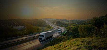 White trucks running on the road at sunset