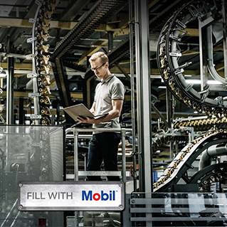 Mobil engineer standing with a computer in a factory